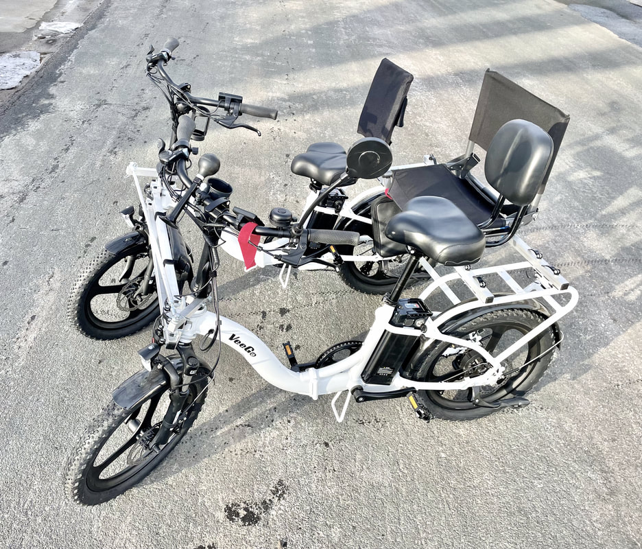 Electric bikes attached side by side as a sociable tandem